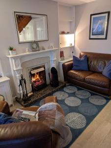 a living room with a couch and a fireplace at Widows Row Cottage in Newcastle