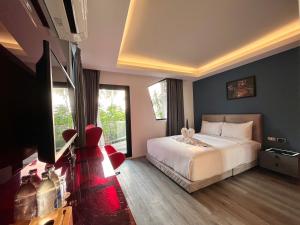 a hotel room with a bed and a television at Stardust Boutique Hotel in Hua Hin