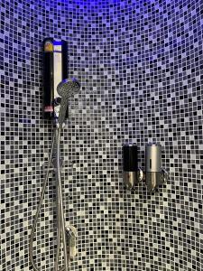 a shower in a bathroom with a black and white tiled wall at Stardust Boutique Hotel in Hua Hin