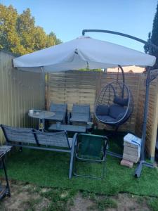 an umbrella and chairs and a table and a swing at Second&Home in Przeźmierowo