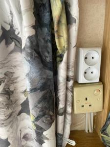 a lightswitch with two faces on it next to a bed at Second&Home in Przeźmierowo