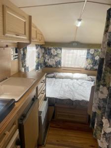 a small kitchen with a bed in a caravan at Second&Home in Przeźmierowo