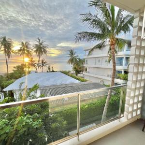 a balcony with a view of a building and a palm tree at Stardust Boutique Hotel in Hua Hin