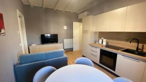 a living room with a blue couch and a kitchen at Appartamento indipendente Apt 3 in Piadena