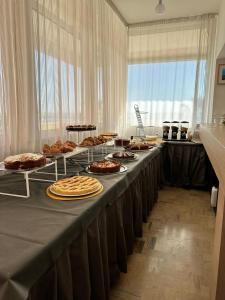 ein langer Tisch mit Tellern voller Essen darauf in der Unterkunft Hotel Carnaby in Rimini