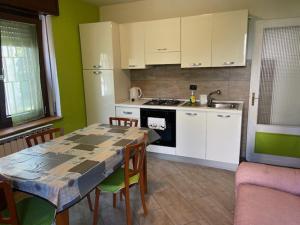 a kitchen with a table and chairs and a kitchen with white cabinets at CA' DEI PAOLI in Pieve Vergonte
