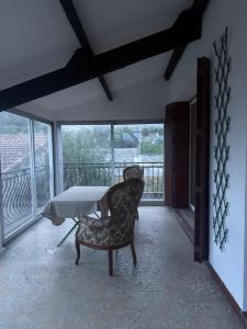 a room with a table and a chair on a balcony at Maison DARDECH in Rochemaure