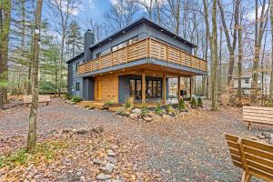 a house in the woods with two benches at Pine Breeze in Pocono Pines