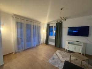 a living room with a flat screen tv on the wall at Maison DARDECH in Rochemaure +8 photos