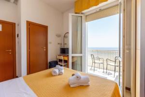 ein Hotelzimmer mit einem Bett, auf dem Handtücher liegen in der Unterkunft Hotel Carnaby in Rimini