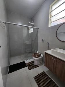 a bathroom with a shower and a toilet and a sink at Casa simples e funcional in Aimorés