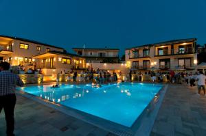 een groot blauw zwembad met mensen eromheen. bij The View Hotel Perdika in Perdika