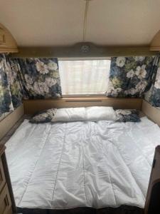 a large white bed in a room with a window at Second&Home in Przeźmierowo