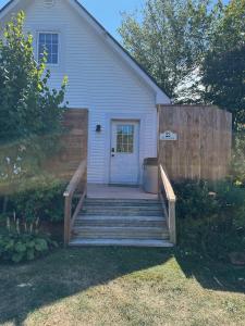 a house with a wooden staircase leading to a door at The Laurel Leaf at Annes Windy Poplars in Cavendish