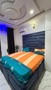 a large bed in a room with a blue head board at ComfortHomes in Ahor