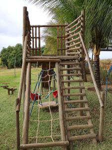 a wooden playground with a ladder and a swing at Rancho da Montanha Chalé Lua in Resplendor