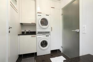 a white laundry room with a washer and dryer at Villa Graniitti in Imatra