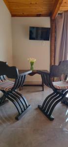 two chairs and a table with a vase of flowers at Chalé Pôr do Sol in Cunha
