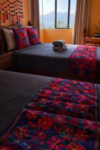 a bedroom with a bed with a colorful quilt at Casa Josvic in San Cristóbal de Las Casas