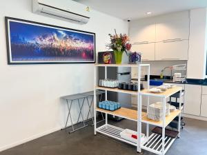 a kitchen with a white shelf and a painting on the wall at Stardust Boutique Hotel in Hua Hin +52 photos