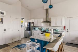a kitchen with white cabinets and a blue island at Deja View - Ocean View Neskowin Luxury in Neskowin
