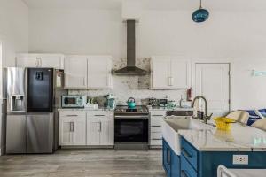 a kitchen with white appliances and blue cabinets at Deja View - Ocean View Neskowin Luxury in Neskowin +46 photos