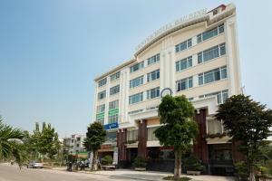 ein großes weißes Gebäude mit Bäumen davor in der Unterkunft Center Hotel Bac Ninh in Bắc Ninh