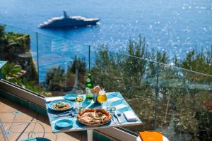 a table with a pizza on it with a view of the ocean at Grand Hotel Tritone in Praiano