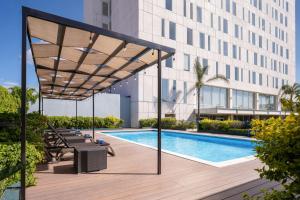 a view of a building with a swimming pool at Courtyard by Marriott Leon at The Poliforum in León