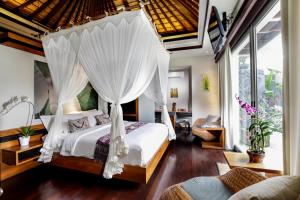 a bedroom with a bed with a canopy at Sunset Paradise Villa Jimbaran 8008 in Jimbaran