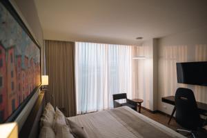 a hotel room with a bed and a desk and a window at Metria Hotel in León