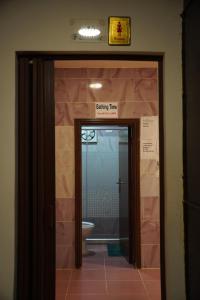 a bathroom with a toilet and a door leading into a room at Petra voyager Hostel in Wadi Musa +40 photos