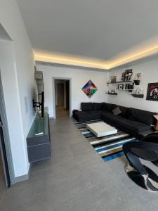 a living room with a black couch and a rug at Villa Panama con piscina - Mazara del vallo in Mazara del Vallo
