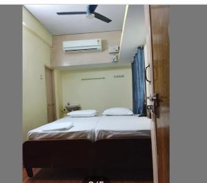 a bedroom with a bed with a ceiling fan at JB lodge in Chidambaram