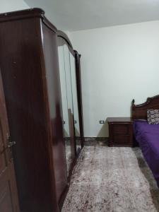 a bedroom with a bed and a dresser and a door at الشقة العائلية الحديثة familial new flat in Amman