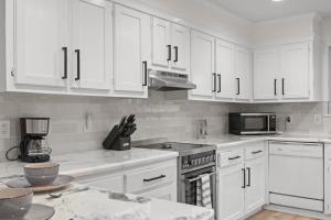 a kitchen with white cabinets and a stove top oven at The Tanglewood Upper Suite in Chattanooga