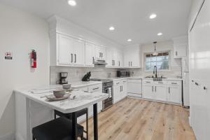 a kitchen with white cabinets and a wooden floor at The Tanglewood Upper Suite in Chattanooga
