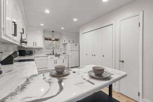 a white kitchen with a table with two bowls on it at The Tanglewood Upper Suite in Chattanooga