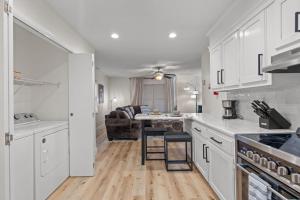 a kitchen with white cabinets and a living room at The Tanglewood Upper Suite in Chattanooga