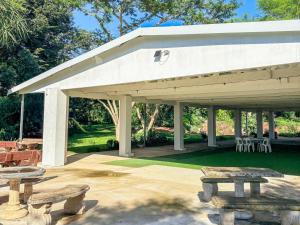 a white pavilion with picnic tables and chairs at Aintree Lodge in Pietermaritzburg +11 photos