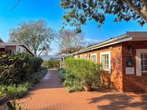an old brick building with a brick walkway at Aintree Lodge in Pietermaritzburg