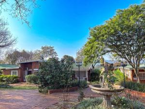 a statue of a dog in a fountain in front of a house at Aintree Lodge in Pietermaritzburg