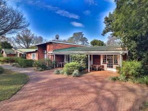 a brick house with a brick driveway at Aintree Lodge in Pietermaritzburg