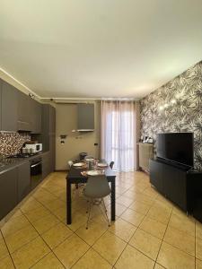 a kitchen with a table and a dining room at CASA di MIRCO -Ampio moderno bilocale per 4 ospiti in Castenedolo