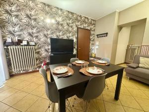 a dining room with a black table and chairs at CASA di MIRCO -Ampio moderno bilocale per 4 ospiti in Castenedolo