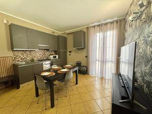 a kitchen with a table and chairs in a room at CASA di MIRCO -Ampio moderno bilocale per 4 ospiti in Castenedolo