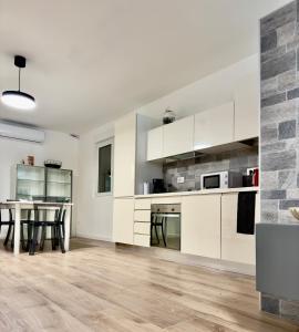 an open kitchen with white cabinets and a table at LP House in Rovereto