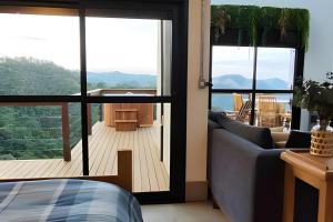 a living room with a couch and a balcony at Cabana do Café - Olivais Santa Clara in Cambuí