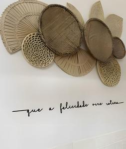 a bunch of wooden plates hanging on a wall at Cabana do Café - Olivais Santa Clara in Cambuí