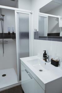 a white bathroom with a shower and a sink at Imprenta Musical Alojamiento in Astorga +129 photos